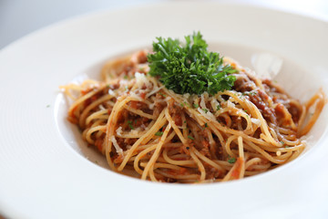 spaghetti Bolognese with minced beef and tomato sauce garnished with parmesan cheese and basil , Italian food