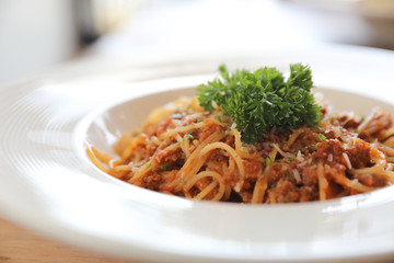 spaghetti Bolognese with minced beef and tomato sauce garnished with parmesan cheese and basil , Italian food