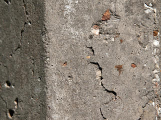 Old flaky white paint peeling off a grungy cracked wall. Cracks, scrapes, peeling old paint and plaster on background of old cement wall. An old cement stone wall as vintage cracked.