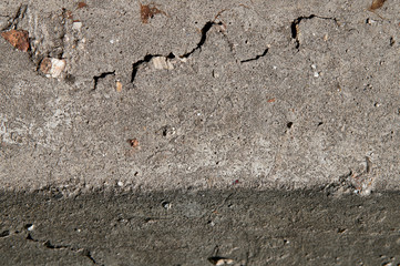 Old flaky white paint peeling off a grungy cracked wall. Cracks, scrapes, peeling old paint and plaster on background of old cement wall. An old cement stone wall as vintage cracked.