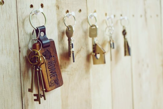 House Key With Wooden Home Keyring Hanging On Wood Board Background, Property Concept, Copy Space