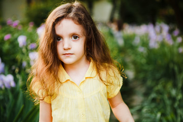 A small, curly girl in a yellow dress.