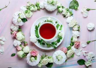 White cup of spring tea with rose petals