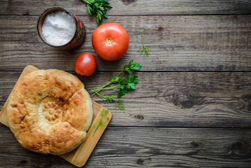 Bread cake and tomatoes on wooden background