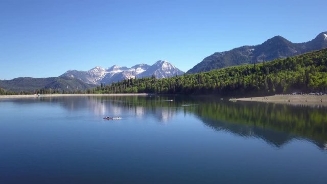 Flying over lake past people lying on paddle boards at Silver Lake Flats in Utah.