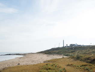 A deserted beach with a lighthouse in the background in Australia