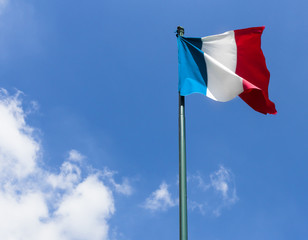 French flag against blue cloudy sky