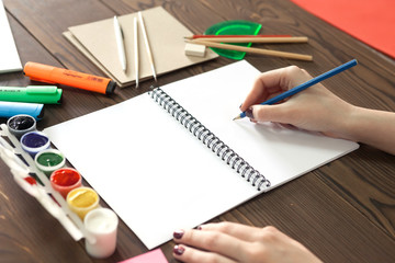 the girl draws a pencil in a notebook