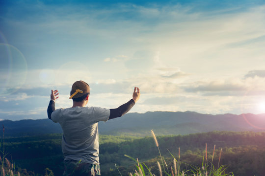 christian people worship God over the cross in cloudy sky