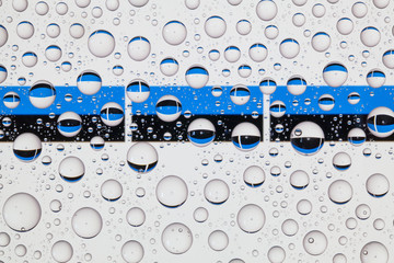 Water drops on glass and flags of Estonia