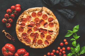 Tasty pepperoni pizza on black concrete background, top view