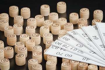 Wooden barrels lotto and cards. Black wooden table.