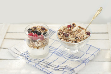 Granola with berries and yogurt on a wooden table. Traditional American Breakfast