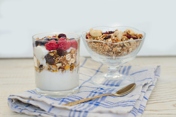 Granola with berries and yogurt on a wooden table. Traditional American Breakfast