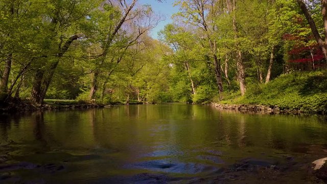 Very low angle backwards dolly over a calmly rippling Connecticut River