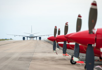 Jet passenger craft with red planes in foreground 