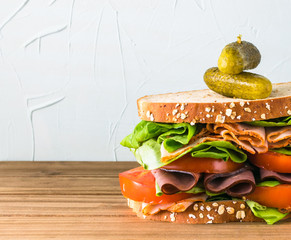 Deli sandwich with variety of meats on oat bread with turkey and black forest ham