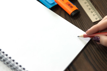 the girl draws a pencil in a notebook