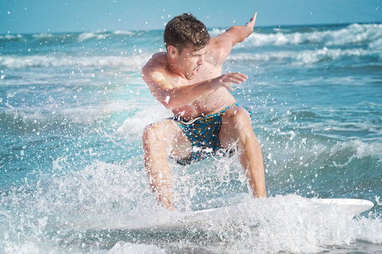 Skimboarding young man ocean
