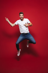 Full length portrait of a cheerful young bearded man