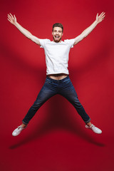 Full length portrait of a cheerful young bearded man