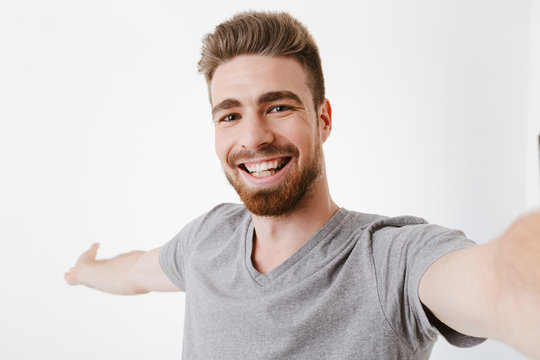 Portrait of a cheerful young bearded man taking a selfie