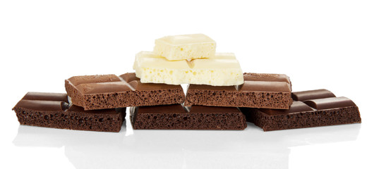 Pieces of black porous, milk and white chocolate isolated on white