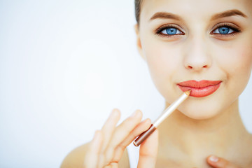 Beauty and Care. Portrait of a Young Woman with a Beautiful Skin. Beautiful Lips. Girl Holding Lipstick in her Hands. Woman with Beautiful Blue Eyes. Makeup. Care for the Lips