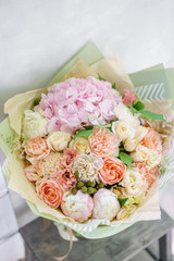 beautiful spring bouquet. flower arrangement with hydrangea and peonies. Color light pink. The concept of a flower shop, a small family business