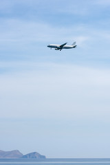 Fototapeta na wymiar Airplane above sea, prepares to land on the island of Crete