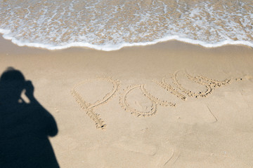 HDR shot of sea shore with wave and white sand during summer day in thailand with shadow of man holding camera (selective focus and white balance / color tone shift )
