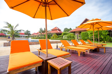 orange beach umbrella in a sunny day in thailand (with selective focus and tone adjustment)