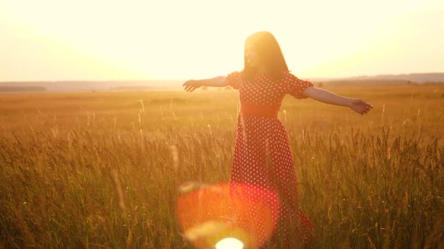 slow motion video. beautiful girl whirls in the field hands in the hand silhouette lifestyle at sunset sunlight. woman concept freedom joy happiness travel