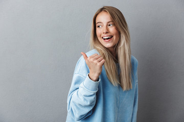 Portrait of a cheerful young girl in blue sweatshirt