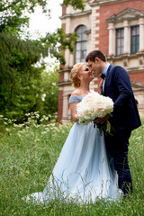 Bride and groom on the background of an old estate. Classical wedding. Wedding walk and photo shoot. Embraces and kiss