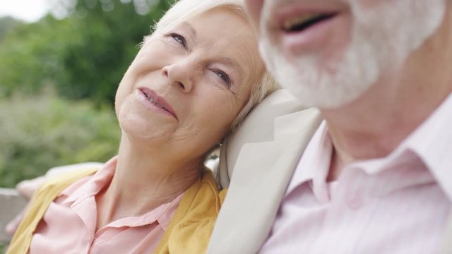 Senior couple in love as woman listens to her partner as she rests on his shoulder