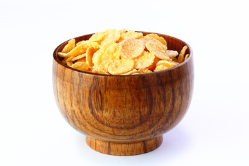 cornflakes in wooden bowl on table