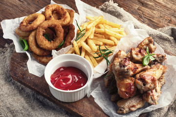Fast food snacks - onion rings, fries and chicken wings