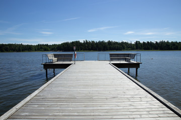 Fototapeta premium Drewniane molo w jeziorze ze znakiem ostrzegawczym „nie pozwalaj pływać”