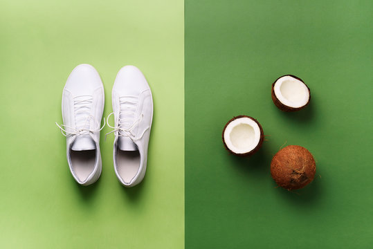 Stylish White Sneakers And Rope On Green Background With Copy Space. Top View. Minimal Flat Lay. Summer Shoes Collection. Sport, Tennis, Golf Concept. Creative Design