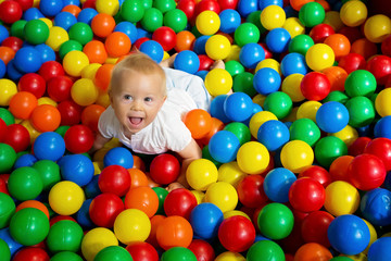 Fototapeta na wymiar Cute toddler boy, child, playing in colorful balls in children playground