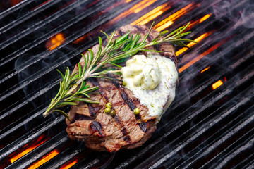 steak on a grill fire, with herbs and butter