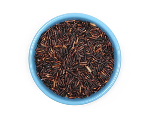 Organic black rice in blue porcelain bowl isolated on white background, top view