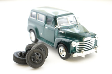 A toy of tire fitting. The car is next to the tires.