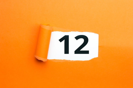 Zahl zw&ouml;lf - 12 verdeckt unter aufgerissenem orangen Papier