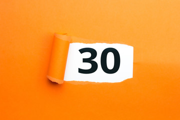Zahl drei&szlig;ig - 30 verdeckt unter aufgerissenem orangen Papier