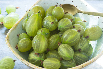 grüne Stachelbeeren in einer Schale mit einem Löffel