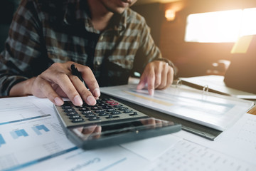 businessman working with calculator for financial document in office. male accountant doing...