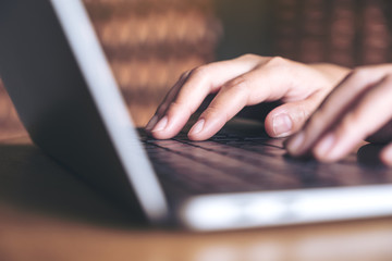 Closeup image of hands working and typing on laptop keyboard in office