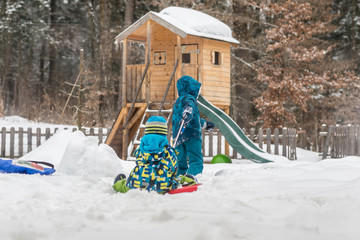 Two children playing outdoors in a winter garden